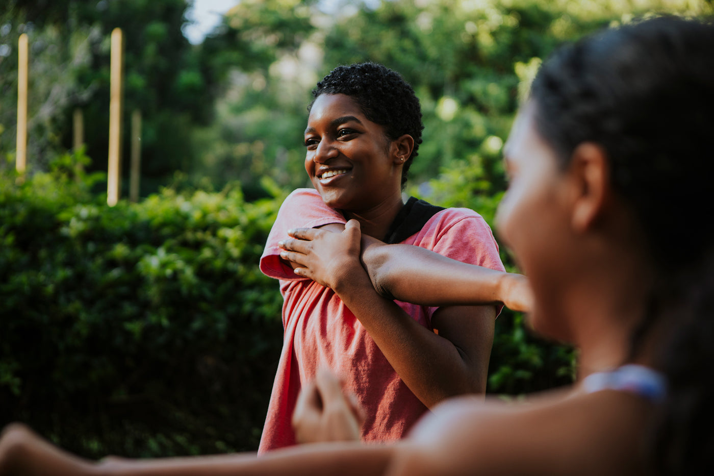 Women stretching their arms outside.