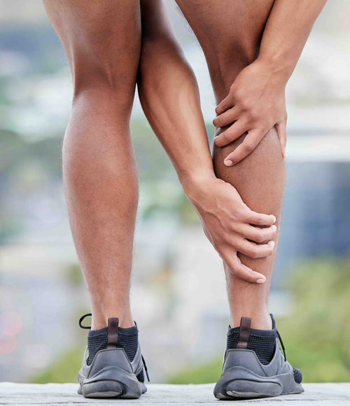 A runner holding their calf in pain.